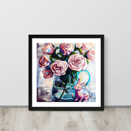 A colorful painting of pink roses in a teal clear vase in a black frame leans against a wall