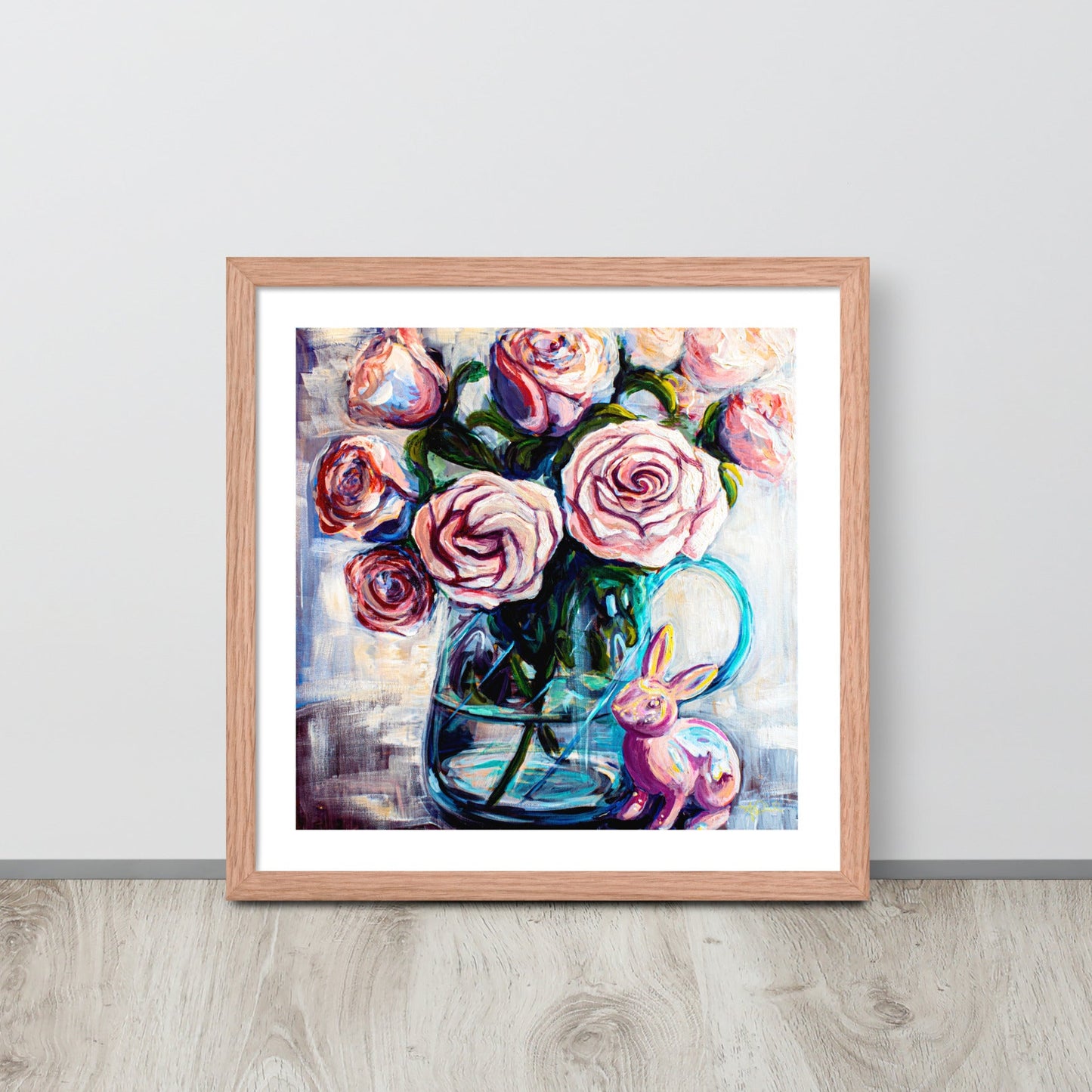 Product mockupA colorful painting of pink roses in a teal clear vase in a red oak frame leans against a wall
