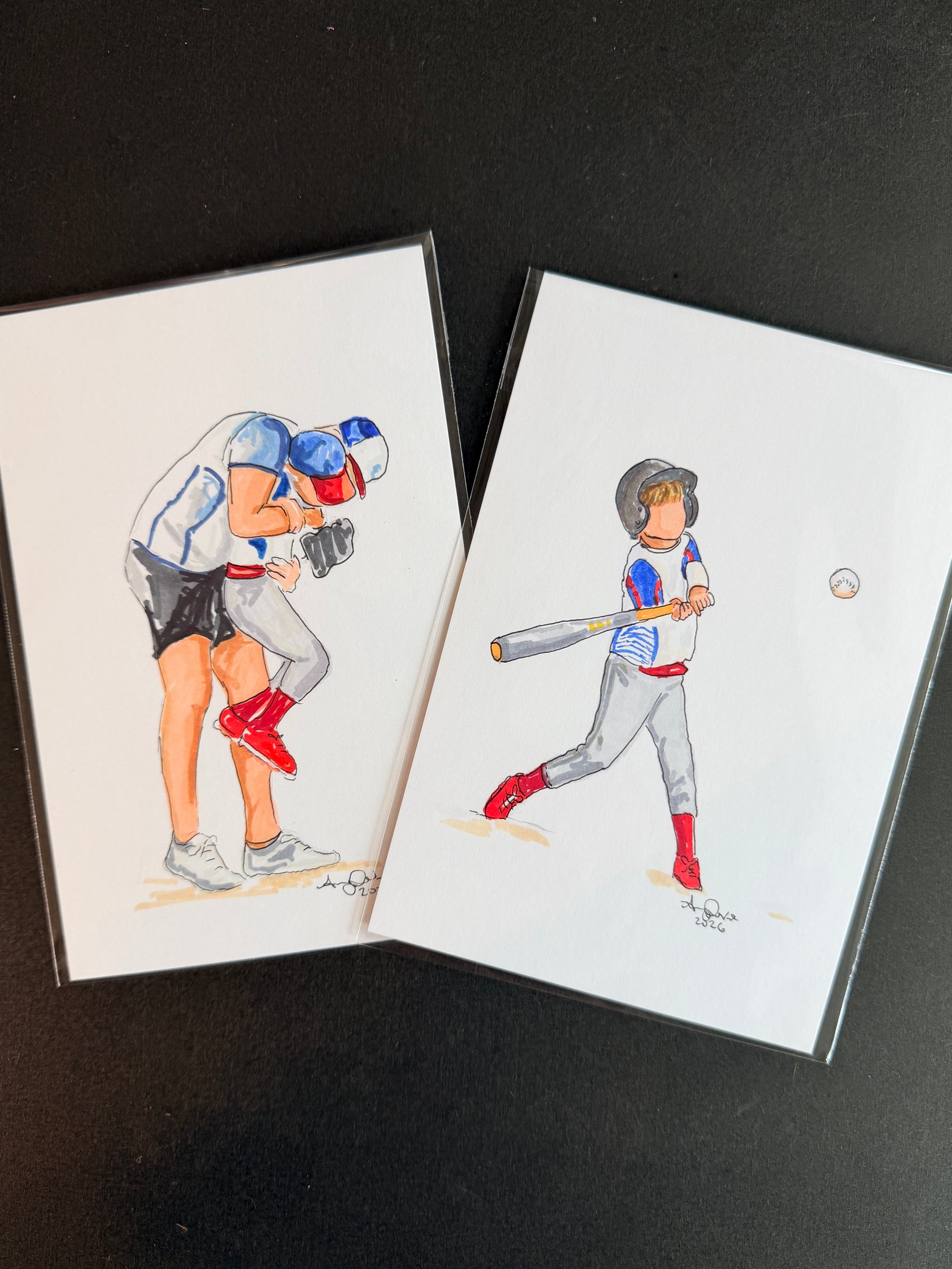 two illustrated cards, one featuring a dad holding a baseball player son. The other has a small baseball player batting