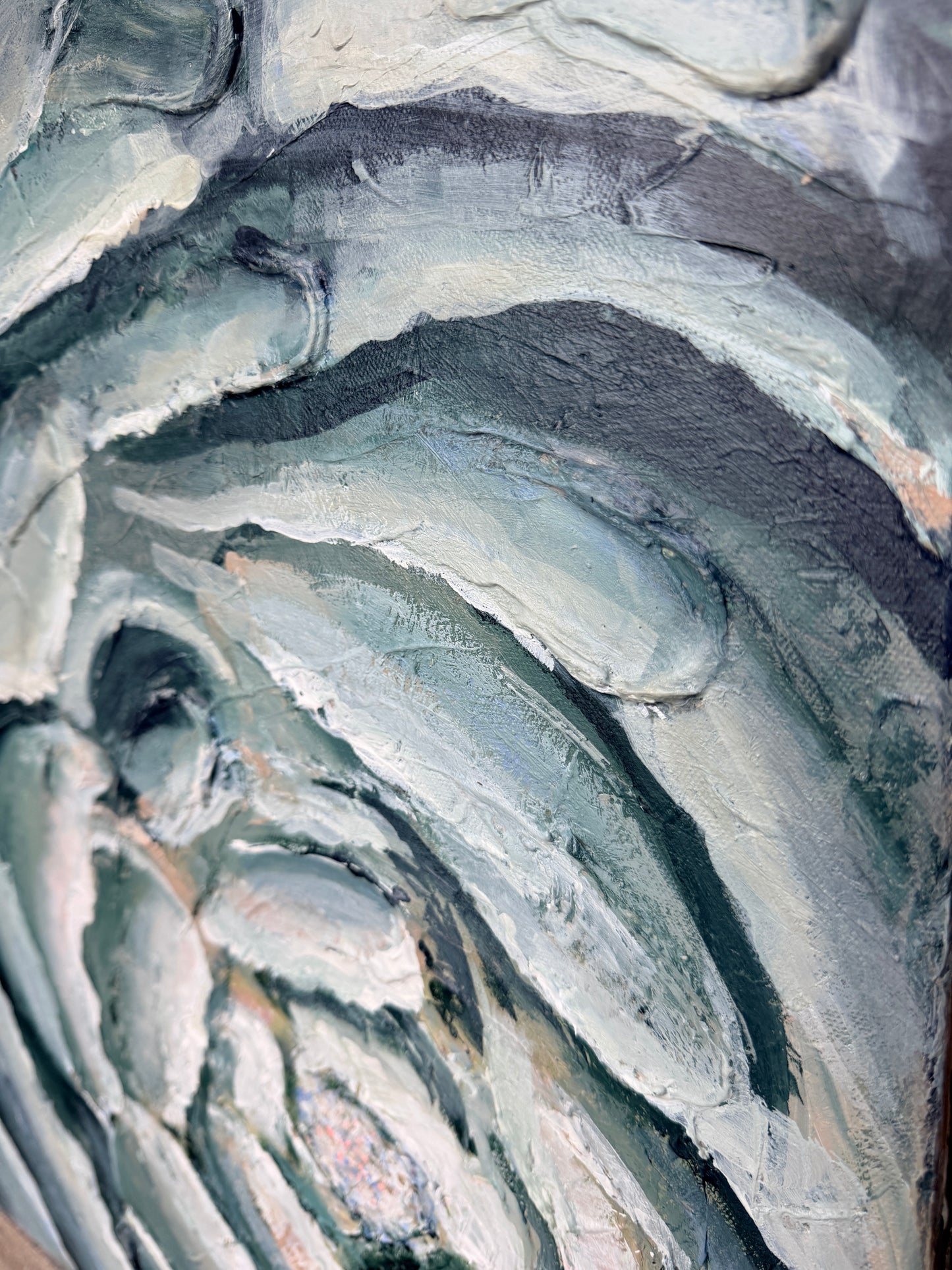 Close-up of textured stone surface with blues, teals, and white and beige tones