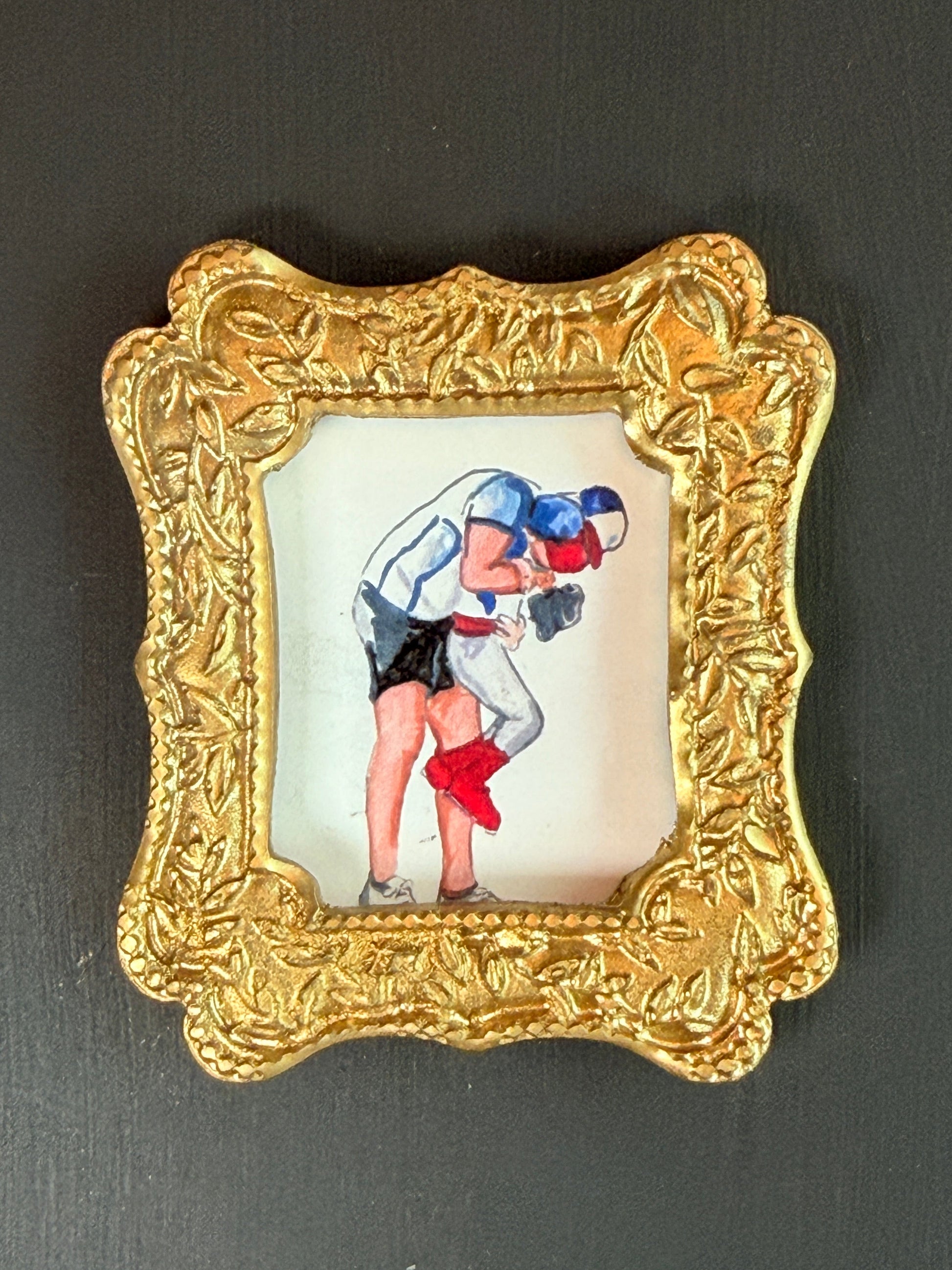 Decorative gold frame with a drawing of  a dad hugging his son on a black background