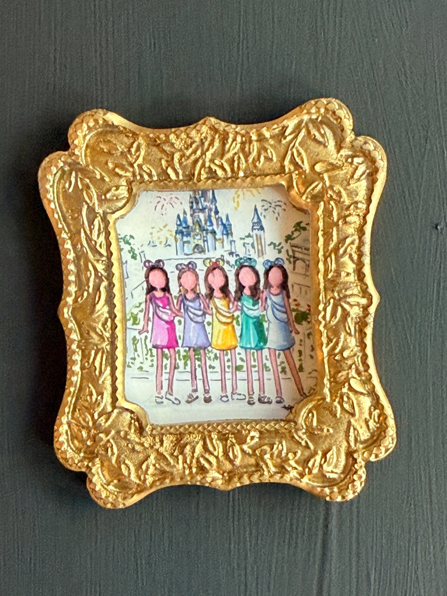 Decorative gold frame with a small illustration of cartoon drawings of women in front of a disney castle