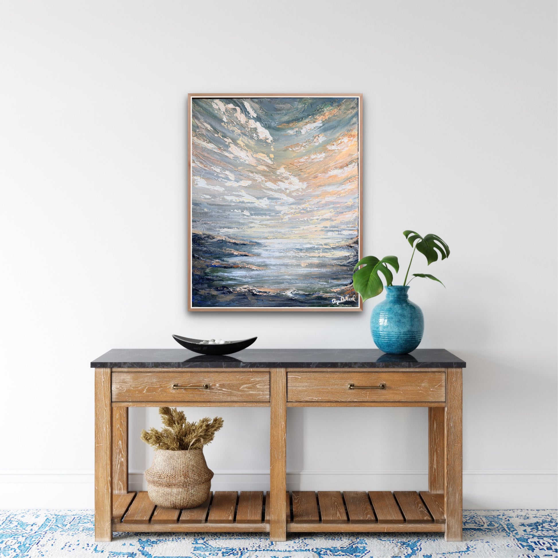 serene beach scene painting hangs above a decorated console table