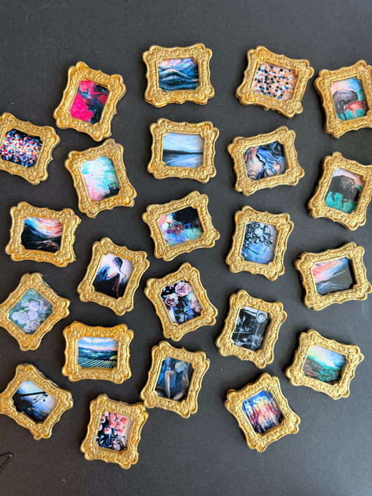 A variety of small gold framed art images spread out over a black background