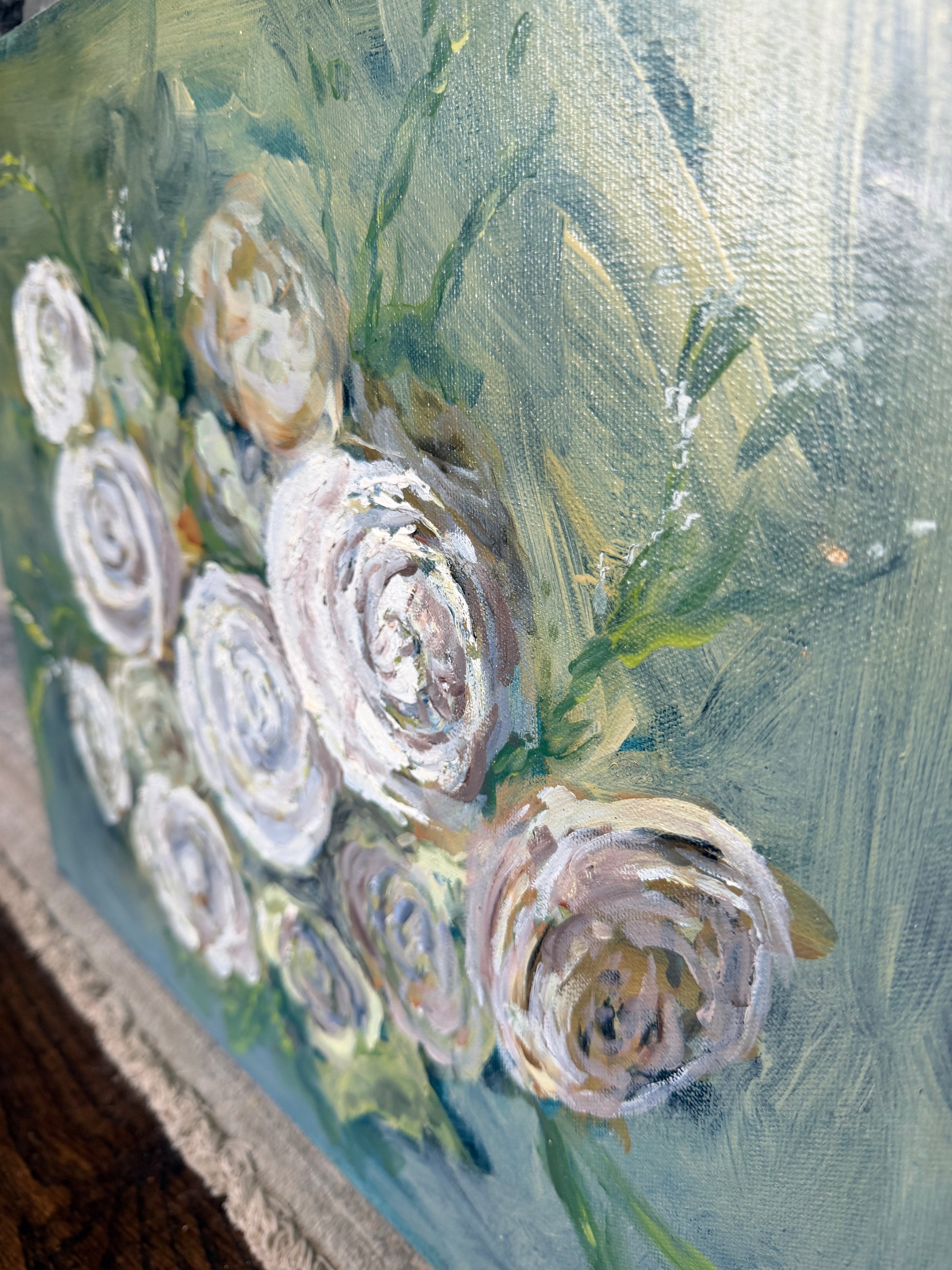 a side close up view of a painting of white roses on a blue green background 