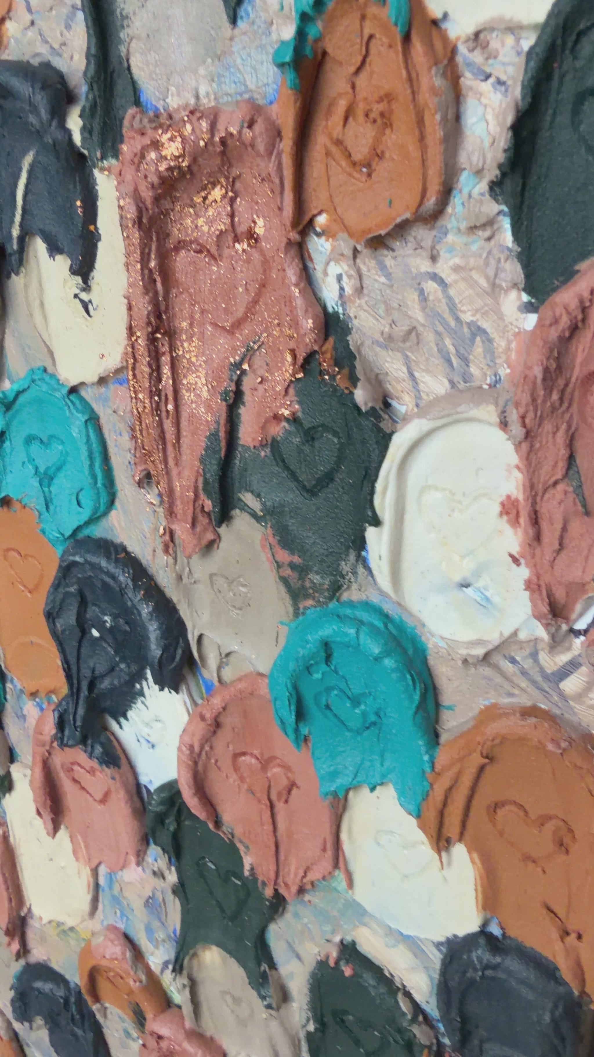 close up of heavily textured painting of dollops of navy, cream, rose gold, and raw sienna with heart carved in them