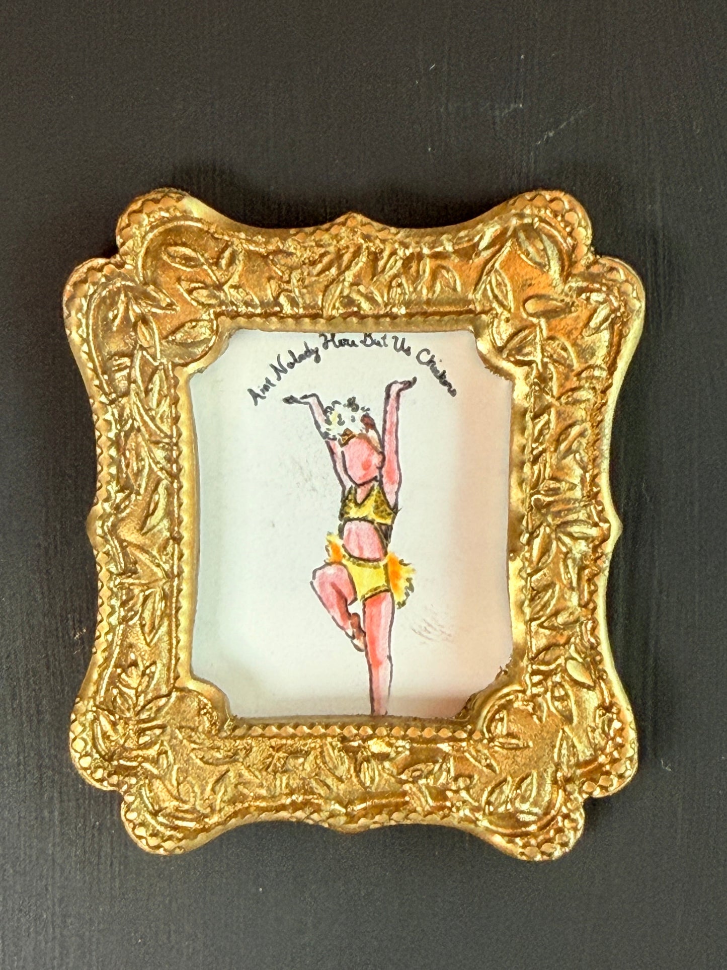 Decorative gold frame with a small painting inside on a dark background