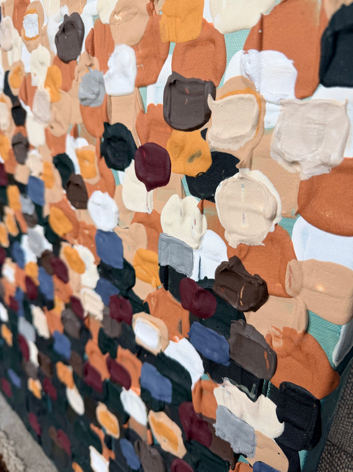 close up of large heavily textured colorful dots of paint arranged in a way that they transition from light to dark
