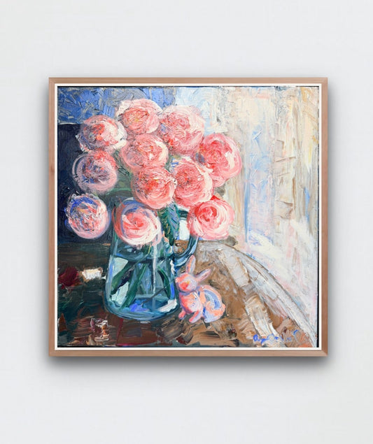 Framed artwork of pink flowers on a white wall 